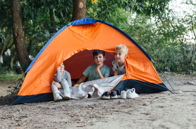 Kids in a tent on a camping trip.